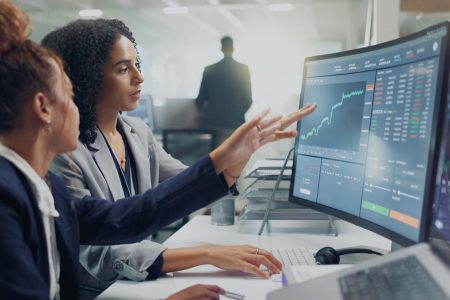 Two business people review market data for accuracy.